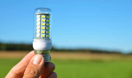 Hand holding eco LED light bulb. Energy saving lamp. Free space for text.の写真素材