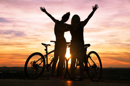 Two cyclist with bicycle at the sunset. Healthy lifestyle concept.の写真素材