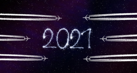Happy New Year concept. Flying airplanes and 2021 writen with sparklers on night sky.