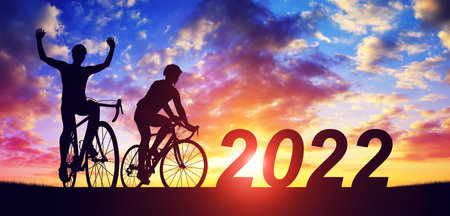 Silhouette of cyclists with bicycles at sunset. Forward to the New Year 2022. Holiday concept.の写真素材