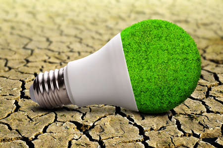 Eco LED light bulb on dry cracked soil. Concepts of environmental conservation, global warming or clean energy.の写真素材