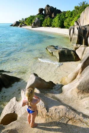 Woman looks at the beach Anse Source d'Argent. La Digue Island, Indian Ocean, Seychelles. Vacations concept.の写真素材