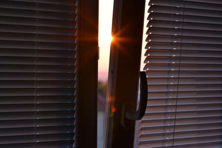 Ajar Window with shutters at sunset.の写真素材