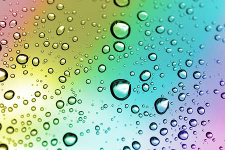 Water drops on a window glass after the rain. Nature background in rainbow color.の写真素材