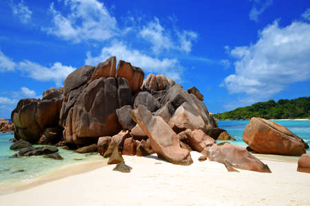 Anse Cocos beach with big granite stones in La Digue Island, Indian Ocean, Seychelles. Tropical landscape with sunny sky. Exotic travel destination.の写真素材