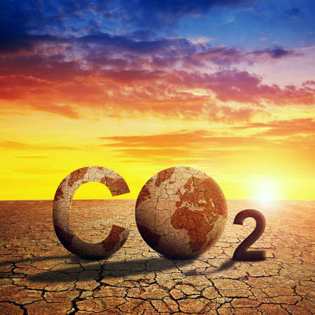 Parched planet earth in the dry landscape with cracked soil at sunset. Global warming or change climate concept. Environmental problems. Growing CO2 in the atmosphere.の写真素材