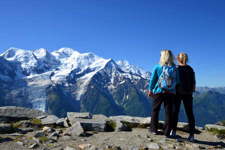 Hikers looking at the Mount Blanc from the summit of Le Brevent. French Alps, Chamonix, France.の写真素材