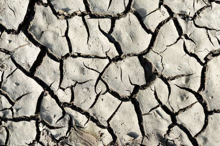 Arid cracked soil as background. Concept of climate change or global warming.の写真素材