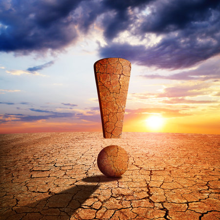 Exclamation mark in the dry landscape with cracked soil at sunset. Global warming or change climate concept. Environmental problems.の写真素材