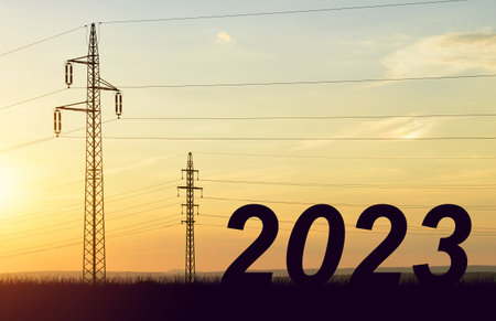The number 2023 with electric pylons at sunset. Concept of high price of electricity or Happy New Year.の写真素材