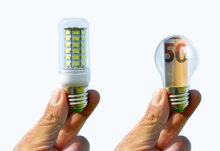 Hands holding light bulb isolated on white background. Concept of saving money for energy.の写真素材