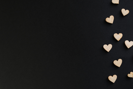 Small wooden hearts on a chalk board, on a black background. There is a place for text. heart for valentines conceptの写真素材