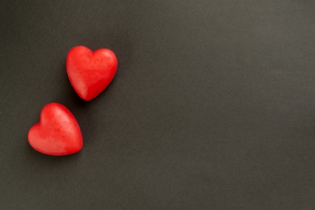 Valentine card with heart decor on a black table. Top view with space for your greeting. The concept of Valentines Day.の写真素材