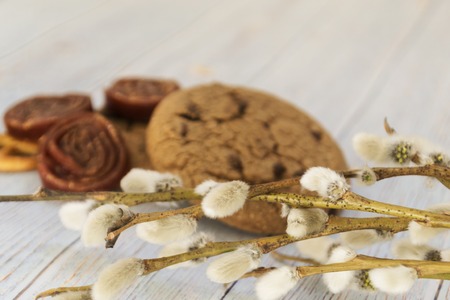 Oatmeal cookies and sweets. Willow branches on a wooden light background. Concept Easter and Palm Sunday.の写真素材