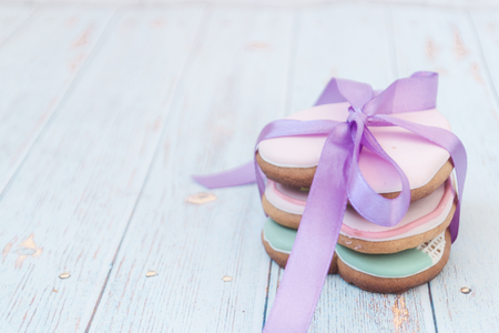 Painted gingerbread on a light wooden background. Tasty cookies in a forepe of hearts. Bakery products. There is for text. Love conceptの写真素材