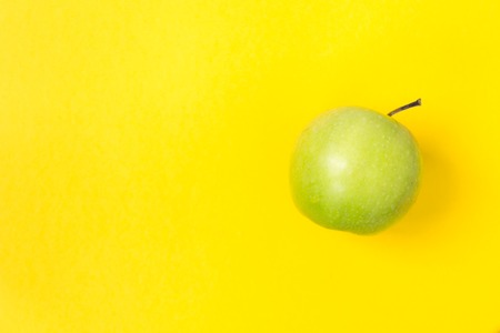 Fresh and green apples on a yellow background. There is a place for text.の写真素材