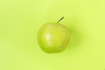 Green apple isolated on green background. There is a place for text.の写真素材