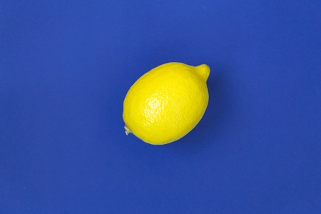 Ripe yellow lemon on blue background. There is a place for text.の写真素材