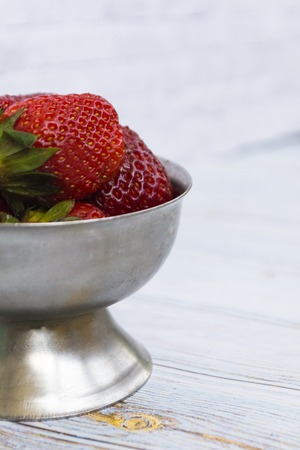Bright ripe strawberry in a metal cups on a light background. Square. Soft focus.の写真素材