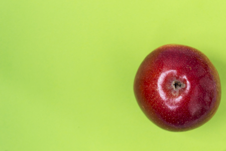 red Apple Isolated on green background. There is a place for text.の写真素材
