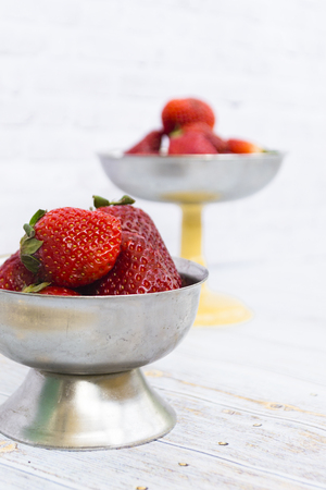 Bright ripe strawberry in a metal cups on a light background. Square. Soft focus.の写真素材