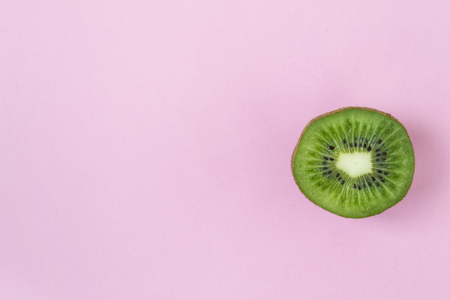 Sliced Kiwi on a pink background. Kiwi on a yellow background. One sliced piece. There is a place for text.の写真素材