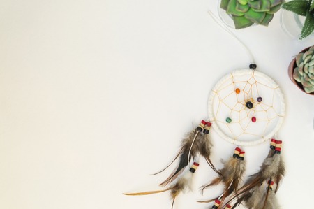 Dream catcher with feathers on a white background with place for text. Next to green and pink...