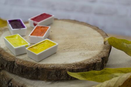 Autumn background with yellow leaves of trees, with yellow, red, orange watercolor paint lies on wooden log cabins. Bright autumn concept.の写真素材