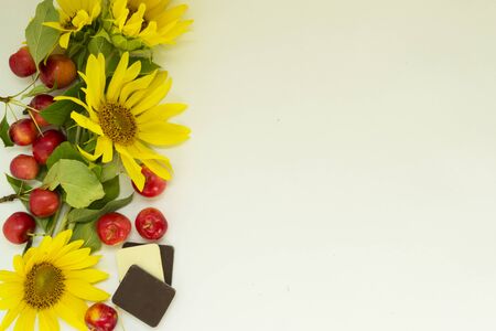 Autumn background Border of yellow sunflower flowers, red apples and chocolate. Harvest holiday concept. There is a place for text.の写真素材