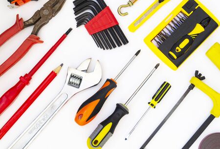Construction tools lie on a white background. Screwdrivers, a saw, a gas wrench, a pencil, pliers, a screwdriver lie as a pattern. The concept of construction, home repair.の写真素材