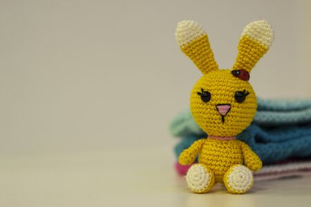 Amigurumi yellow hare sitting on a white background. Needlework concept. There is a place for textの写真素材