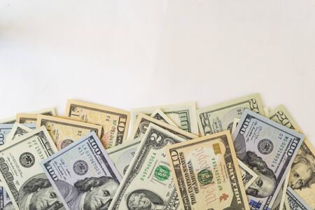 Side frame of different dollar cuperas randomly lie on a white background. Concept business, monetary fund. There is a place for text.の写真素材