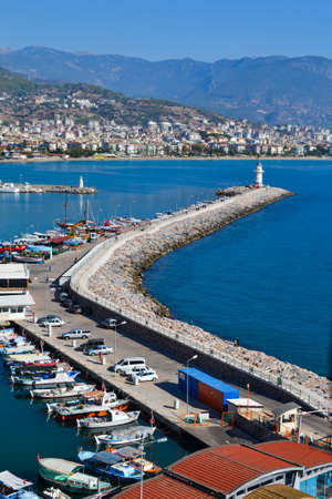 Landscape with a marina and a pier of Kyzyl Kule on the peninsula of Alanya, Antalya region, Turkey. Blue Mediterranean Sea, blue sky, on the horizon mountains and houses of the city. Beach resortのeditorial素材