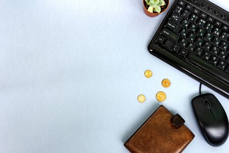 Brown wallet, coins, computer, flower succulent in a pot lie on a gray background. Unemployment concept. View from above.の写真素材