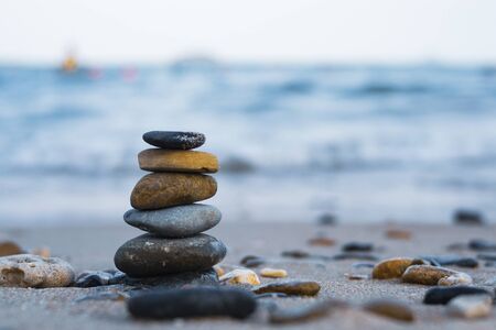 Pebbles are piled on a volcanic rock by the sea. Zen concept. Copy space.の写真素材