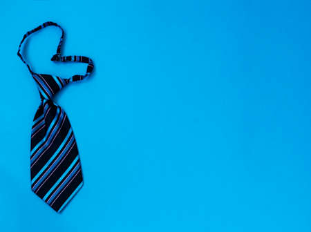 Blue heart-shaped striped tie on a blue background. Copy space.の写真素材