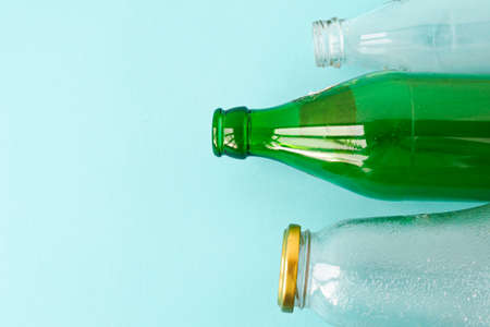 Empty glass transparent and green bottles on a blue background. A copy of the space. Ecology and...