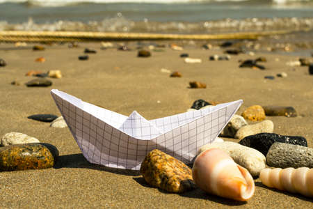 Sunglasses lying on a tropical sandy beach with seashells and stones. Sunglasses on the beach. Nice sea view. Vacation, travel concept.の写真素材