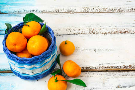 Citrus tangerines lie in a white and blue basket on a white wooden background. Christmas concept. Copy of space.の写真素材