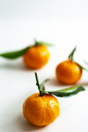 Three ripe tangerines with leaves close-up on a light background. Copy space.の写真素材