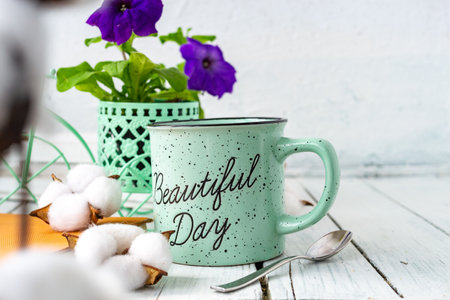 Closeup of a cup of tea on a wooden white table with blur background, front blur. Flat lay. Still life of a flower, a book, a box of cotton. Spring tea. Copy space.の写真素材