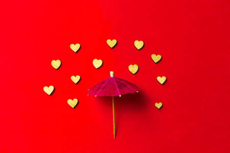 Pink umbrella with heart raindrops on a red background. Copy space. Congratulations to Valentine's day and wedding ..の写真素材