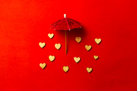 Pink umbrella with heart raindrops on a red background. Copy space. Congratulations to Valentine's day and wedding ..の写真素材