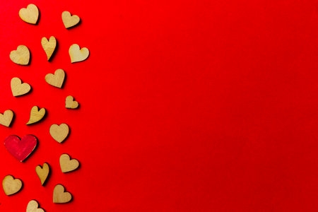 Valentine's day background from wooden and crystal hearts on a red backdrop. Copy space. Love and wedding concept.の写真素材