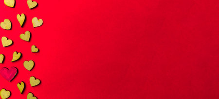 Valentine's day background from wooden and crystal hearts on a red backdrop. Saint valentine long banner. Love and wedding concept.の写真素材