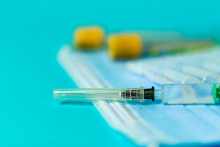 Medical vials for injection, syringe for injection, mask gloves on a blue background. Admission vaccination, flu shotの写真素材