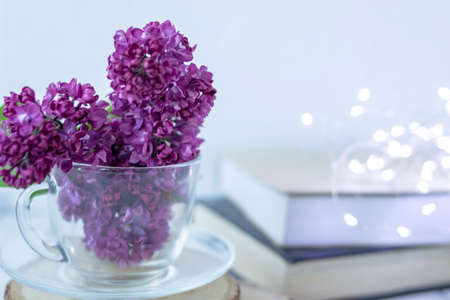 Transparent cup with flowers. Beautiful lilac fills the glass. The spring bouquet is worth no wooden...