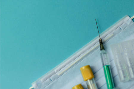 Medical vials for injection, syringe for injection, mask gloves on a blue background. Admission vaccination, flu shot.の写真素材