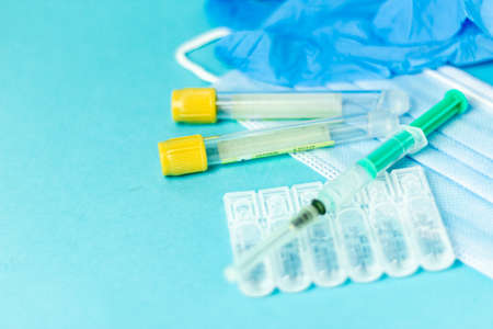 Medical vials for injection, syringe for injection, mask gloves on a blue background. Admission vaccination, flu shotの写真素材