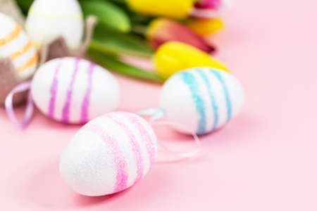 Easter painted eggs with tulips on a pink background. Copy space. Easter celebration conceptの写真素材